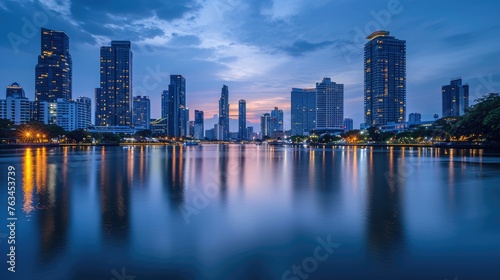 An elegant evening city skyline  lights reflecting on a calm river  skyscrapers silhouetted against a twilight sky  capturing urban beauty. Resplendent.