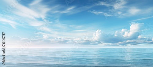 Calm ocean under blue sky with distant clouds © Ilgun