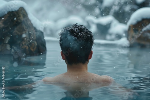 Asian man bathes in a hot thermal spring. Rest. Winter snow. relax