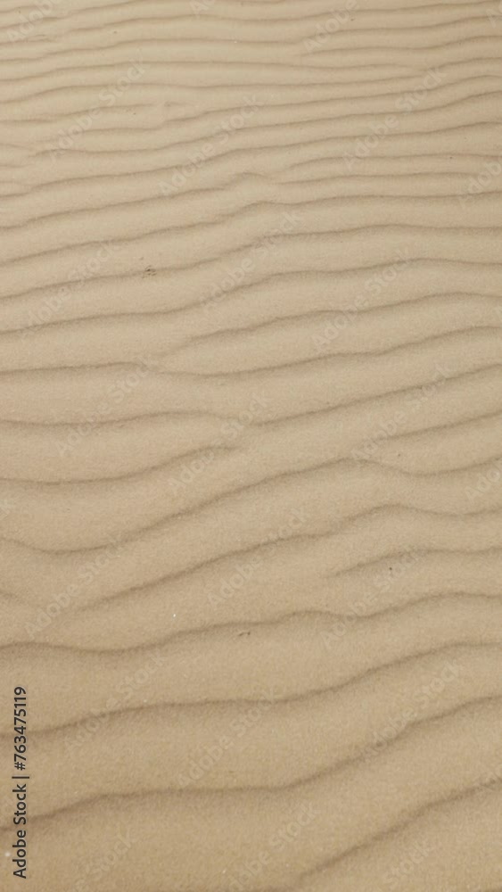 Drone close-up of texture of sand, revealing intricate patterns and details under sunlight, evoking sense of serenity and wonder.Vertical Drone close-up of texture of sand, revealing intricate patterns and details under sunlight, evoking sense of serenity and wonder.Vertical