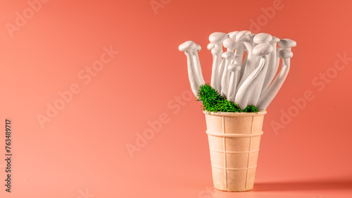 Fototapeta Naklejka Na Ścianę i Meble -  shimeji mushrooms with green moss in an ice cream cone, on bright, colorful, pink background