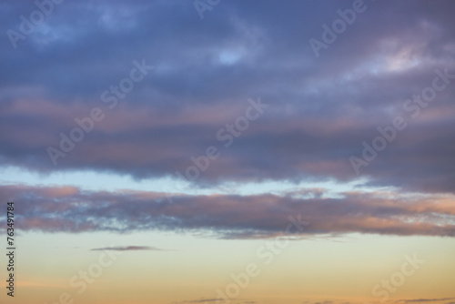 A beautiful sky tinted by the sun leaving vibrant shades of gold, pink, blue and multicolored. Clouds in the twilight evening and morning sky. Cloudy sky background in the evening and during the day.