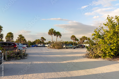 Vehicle parking area with cars parked on ocean beach parking lot at sunset. Summer vacation on beachfront in Southern Florida