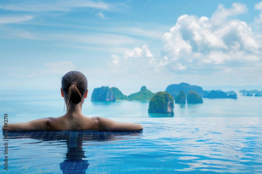 A serene and picturesque image of a woman relaxing in an infinity pool with an expansive view of the sea, promoting relaxation, luxury, and travel