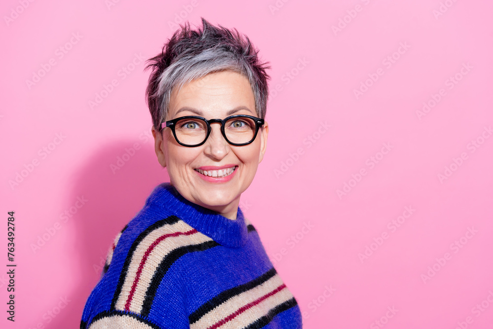 Photo of funny optimistic woman gray hairstyle dressed knitwear sweater smiling to you near empty space isolated on pink color background