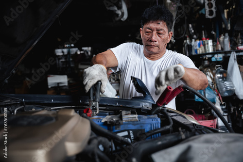 A man is working on a car engine © NewSaetiew