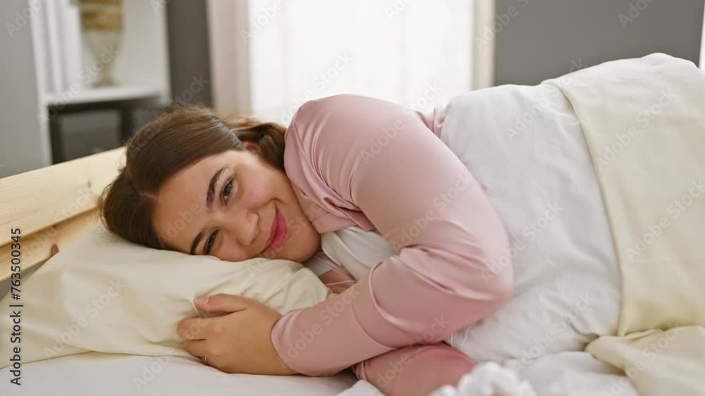 A young hispanic woman enjoys relaxing moments in her bedroom, portraying comfort and leisure. A young hispanic woman enjoys relaxing moments in her bedroom, portraying comfort and leisure.