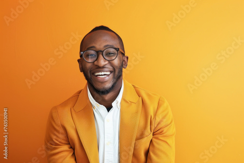 A content man in an orange jacket smiles gently against a plain orange background, exuding warmth and friendliness
