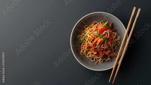 Schezwan noodles, vegetable Hakka noodles, or chow mein, elegantly presented in a bowl or plate alongside wooden chopsticks, offering ample space for text overlays.
