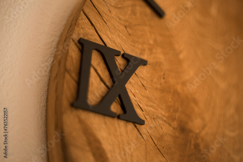 A beautiful wooden clock with black Roman numerals.