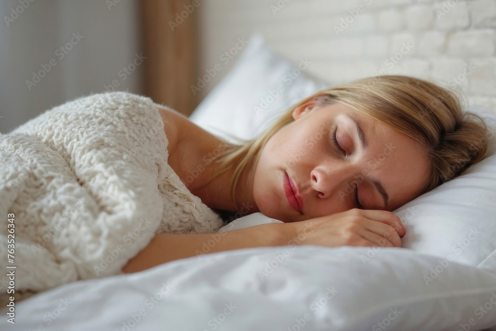 A woman is sleeping on a bed with a white blanket. She has her head on a pillow A woman is sleeping on a bed with a white blanket. She has her head on a pillow