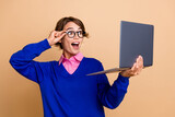 Portrait of impressed cheerful trader girl arm touch eyewear look laptop screen isolated on beige color background