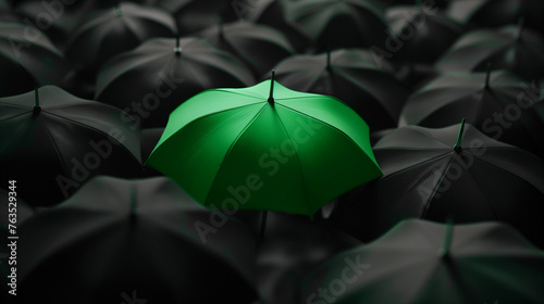 A green umbrella among a crowd of black umbrellas - Concept of success, of being special as a leader, with its own identity, having a difference, new ideas and special skills among the others