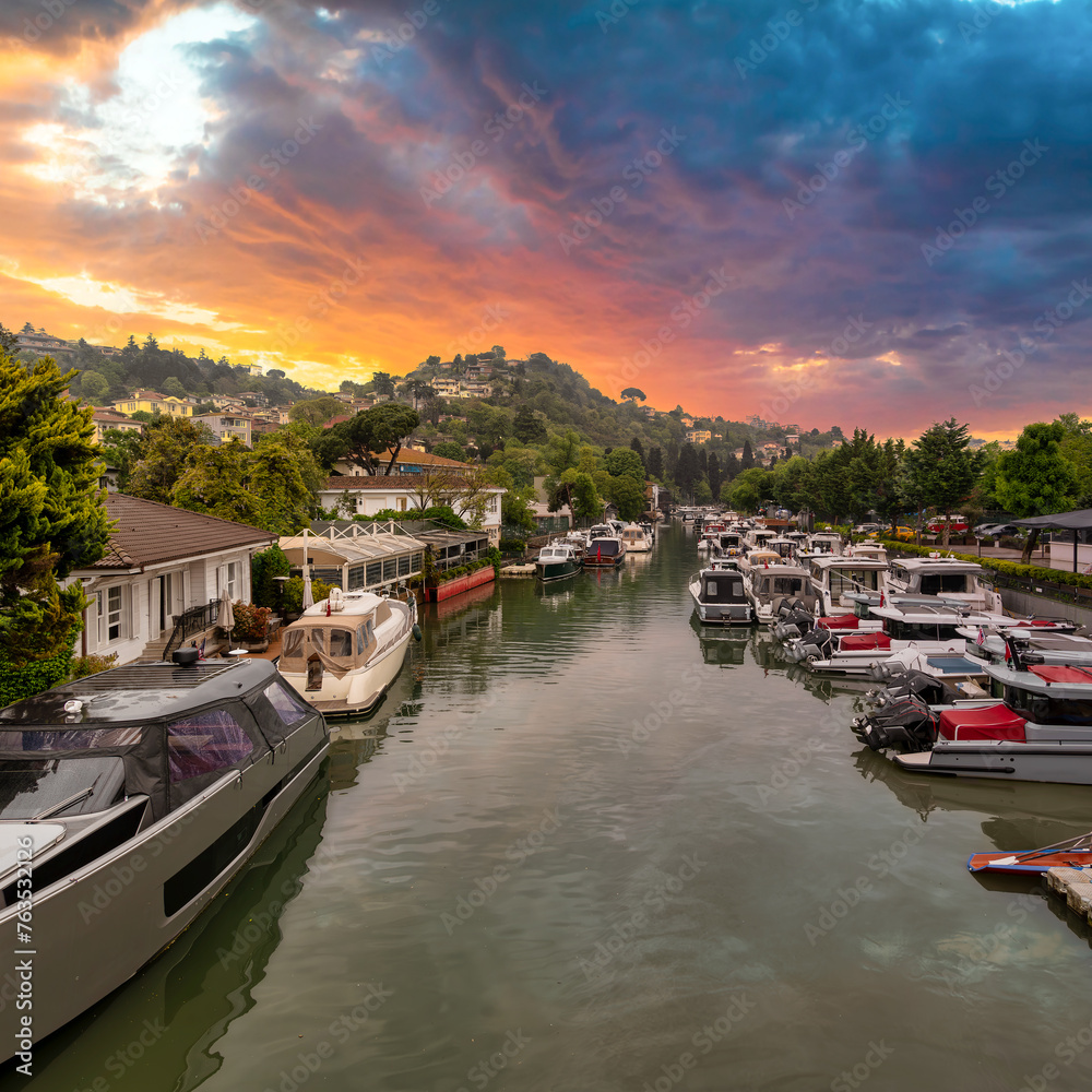 Fototapeta premium Sunset shot of Goksu Stream, with docked group of different shapes, sizes and colors boats, located beside Anadolu Hisari historic castle by the Bosporus strait in Beykoz district, Istanbul, Turkey