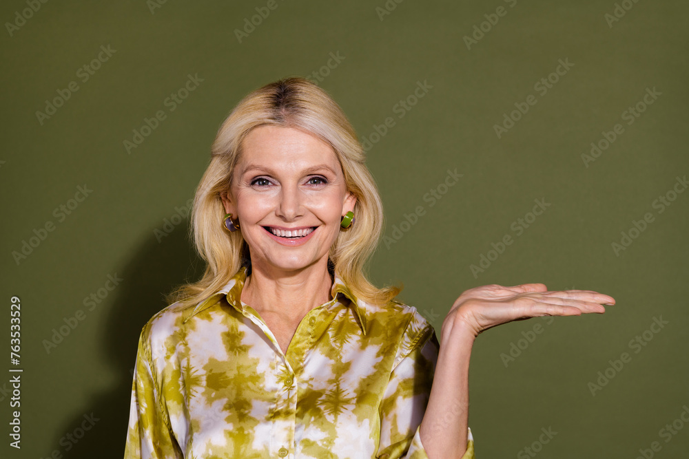 Photo of gorgeous cheerful pretty lady introduces empty space seasonal proposition promo empty space isolated on khaki color background Photo of gorgeous cheerful pretty lady introduces empty space seasonal proposition promo empty space isolated on khaki color background