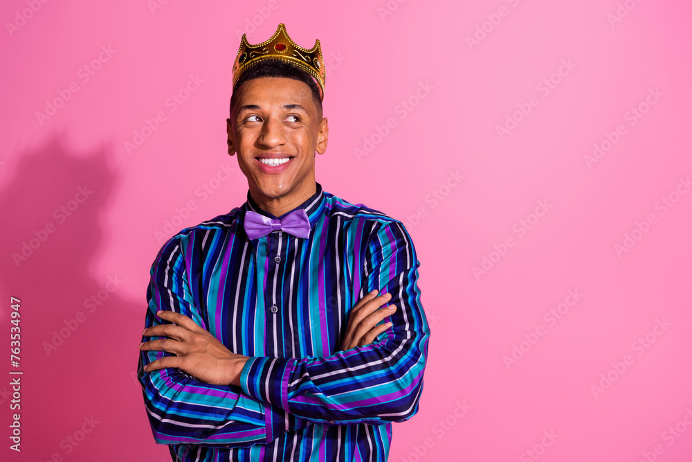 Photo of confident thoughtful guy dressed striped shirt golden tiara arms crossed looking empty space isolated pink color background Photo of confident thoughtful guy dressed striped shirt golden tiara arms crossed looking empty space isolated pink color background