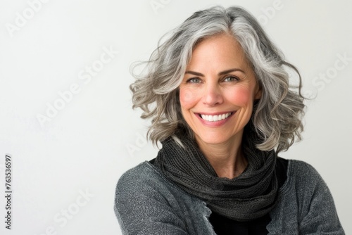 A beautiful woman with gray hair is smiling
