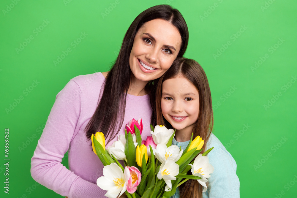 Photo of sweet cute mommy small girl wear casual outfits holding flowers bunch isolated green color background Photo of sweet cute mommy small girl wear casual outfits holding flowers bunch isolated green color background