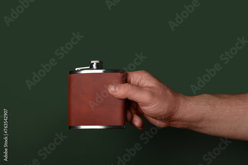 Man holding hip flask on green background