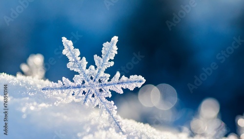 abstract winter pattern from frost with snow and snowflakes with blurred bokeh blue background