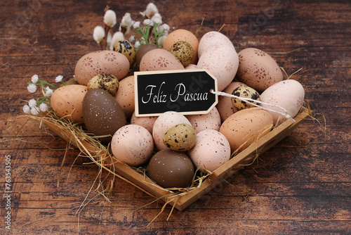 Cesta con huevos de Pascua marrones y el texto Felices Pascuas. photo