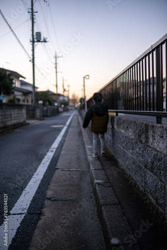 夕方の街の小道を散歩する子供 © AO MEDIA