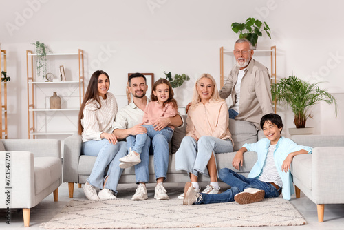 Big family sitting on sofa ...