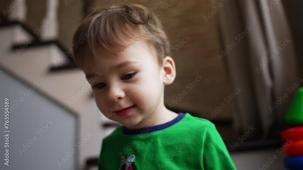 Beautiful Caucasian baby boy with brown hair and dark eyes. Low angle view close up on the cute child sitting on the stairs. Beautiful Caucasian baby boy with brown hair and dark eyes. Low angle view close up on the cute child sitting on the stairs.