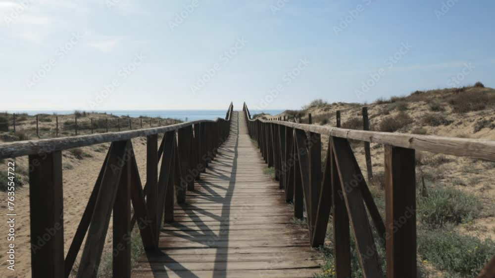 Eco tourism walkway wooden road brown fences sun shines shadow make pattern, blue sky white clouds in background. Eco tourism walkway wooden road brown fences sun shines shadow make pattern, blue sky white clouds in background.