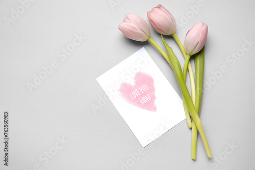 Tulips and festive postcard with text LOVE YOU MOM on white background. Mother's Day celebration