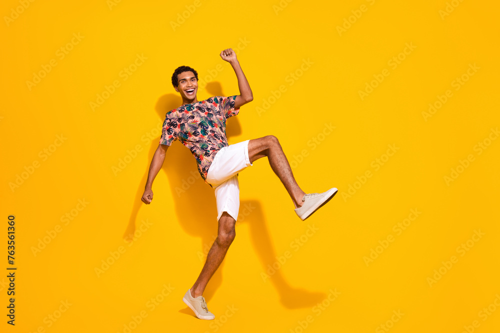 Full length body photo of funky guy big steps to his dream resort place for vacation in tropics isolated on yellow color background