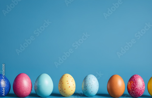 Row of easter painted eggs on blue background.