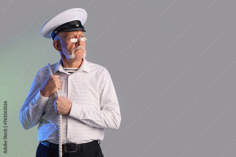 Mature sailor with rope on grey background Mature sailor with rope on grey background
