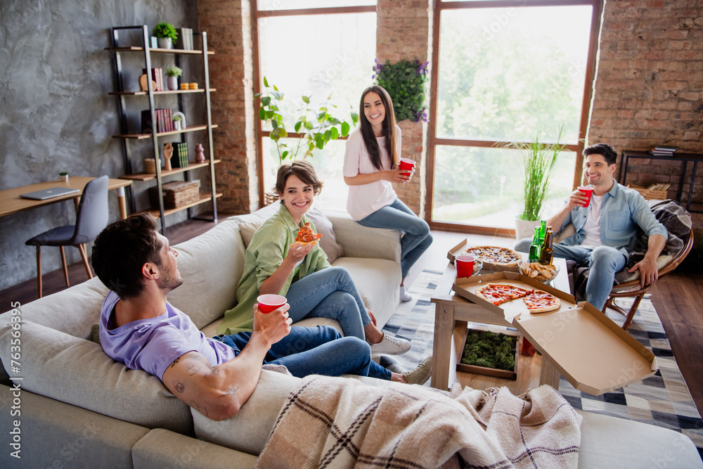 Obraz premium Full length photo of funky fellow groupmates chilling chatting eat pizza drink beer modern interior dorm indoors