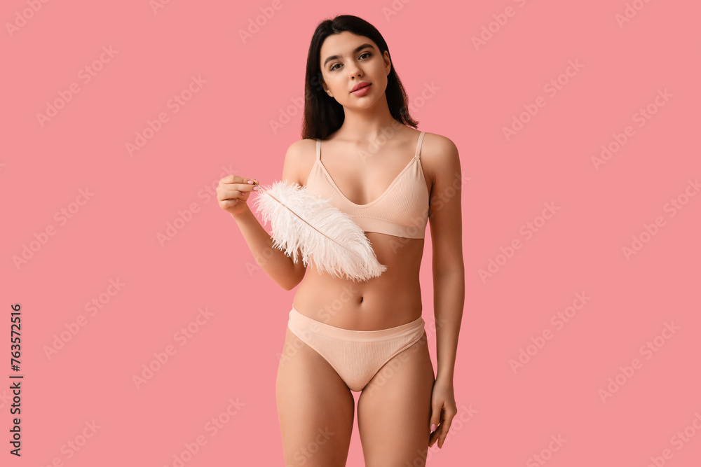 Pretty young woman with soft feather on pink background. Epilation concept Pretty young woman with soft feather on pink background. Epilation concept