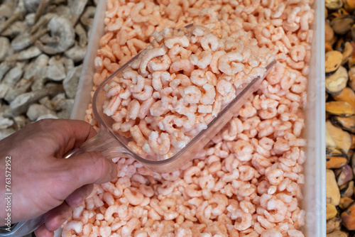 Frozen peeled shrimp are in the grocery store. Sale of marine products.