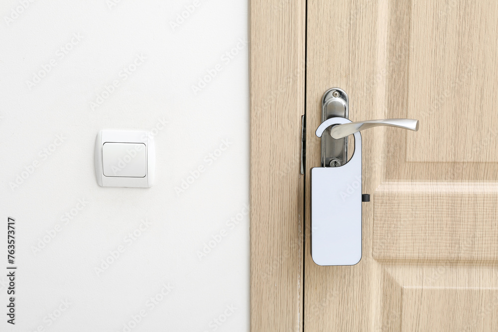 Light wooden door in hotel room with door hanger Light wooden door in hotel room with door hanger