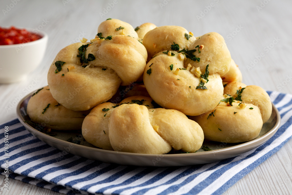 Homemade Garlic Knots with Parsley on a Plate, side view. Homemade Garlic Knots with Parsley on a Plate, side view.
