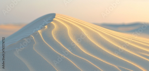 the subtle interplay of light and shadow on a gently undulating sand dune at dusk, emphasizing the quiet beauty of the desert