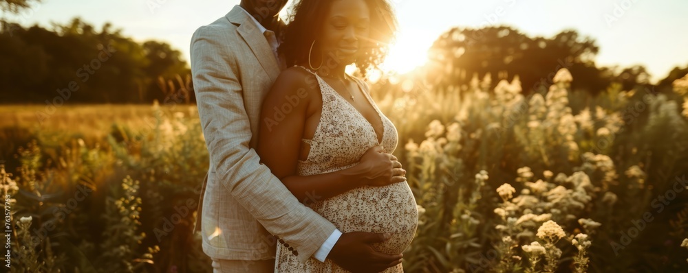 Couple expecting a baby embracing in a sunset field. Maternity and family concept. Design for greeting card, invitation, poster - obrazy, fototapety, plakaty 