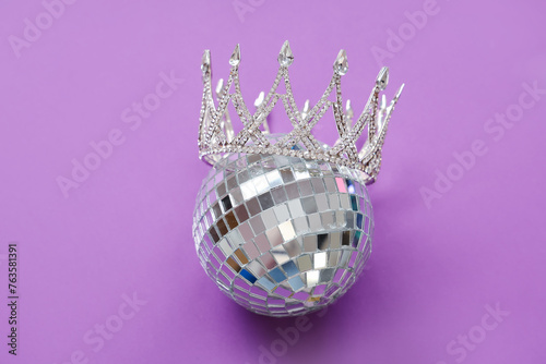 Disco ball with prom crown on purple background photo