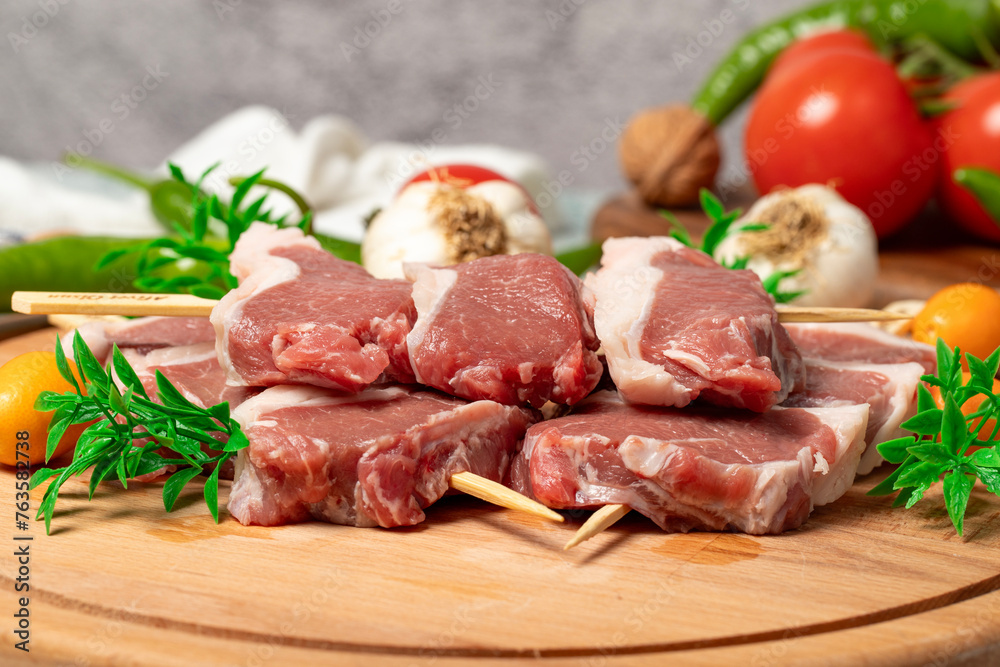 Lamb sirloin. Lamb sirloin meat skewered on a wooden serving board. Close up