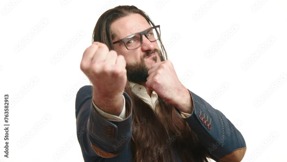 Determined businessman with long hair and beard making aggressive gestures, clenching fists in a show of strength or conflict on a white background. Camera 8K RAW. Determined businessman with long hair and beard making aggressive gestures, clenching fists in a show of strength or conflict on a white background. Camera 8K RAW.
