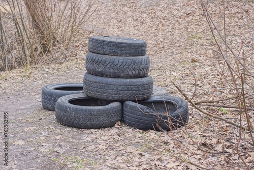 a pile of old black car tires on the gray ground on the street
