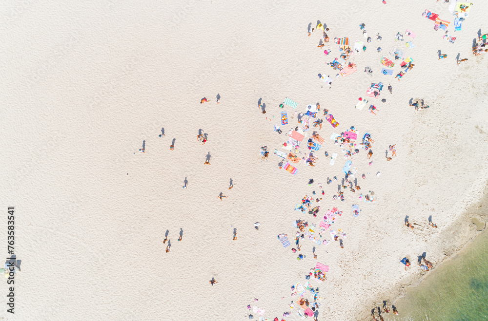 drone aerial view of people enjoying the beach in summer time
