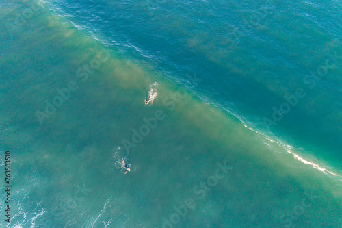 drone aerial top view of two surfers and a wave , sport in summer time concept