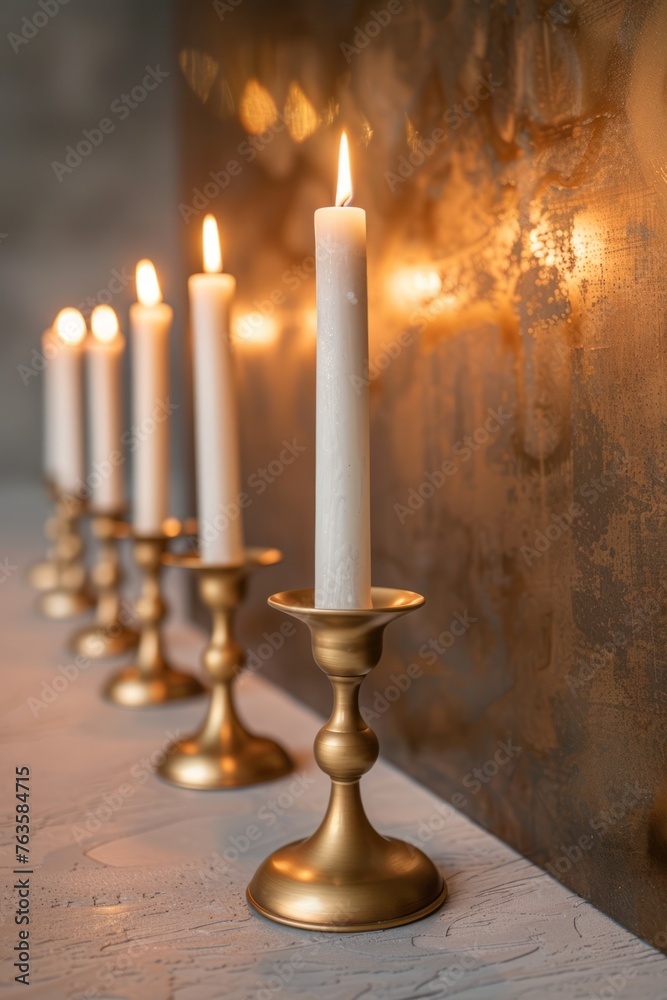 A line of brass candle holders with lit candles, placed neatly on top of a wooden table A line of brass candle holders with lit candles, placed neatly on top of a wooden table