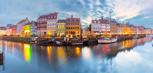 Panorama of Nyhavn with colorful facades of old houses and ships in Old Town of Copenhagen, Denmark.