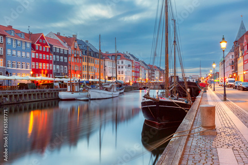 Nyhavn with colorful facades of old houses and ships in Old Town of Copenhagen, Denmark.