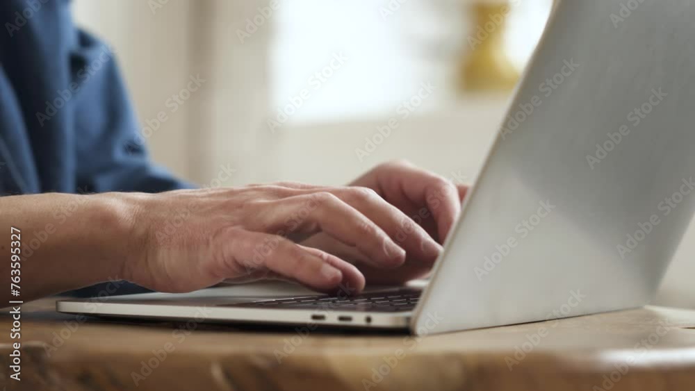 A worker is typing text on the keyboard of a laptop, while sitting in an office environment.
A worker is typing text on the keyboard of a laptop, while sitting in an office environment.
